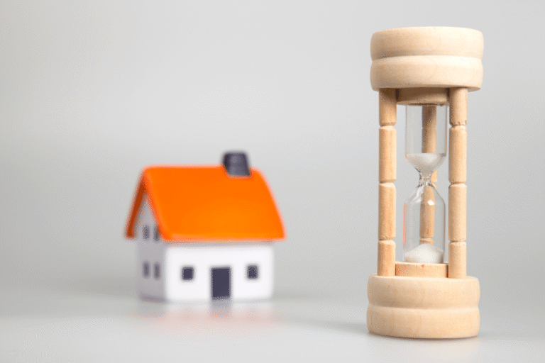 Sabliers en bois à côté d'une maison miniature.