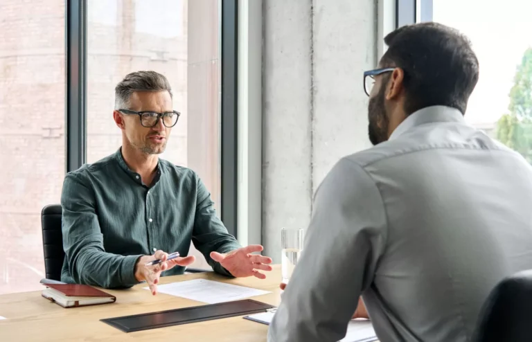 Homme en chemise verte discute lors d'un entretien.