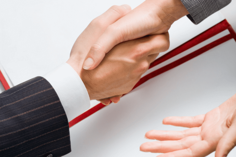 Poignée de main entre deux personnes en costume.