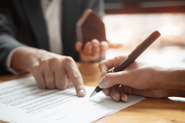 Signature d'un contrat avec une main pointant un document.