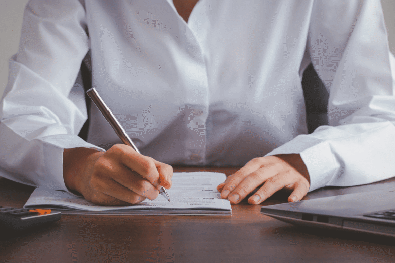 Rédaction d'un document avec une main tenant un stylo.