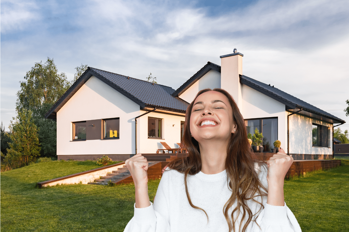 Femme souriante devant une maison moderne avec jardin.