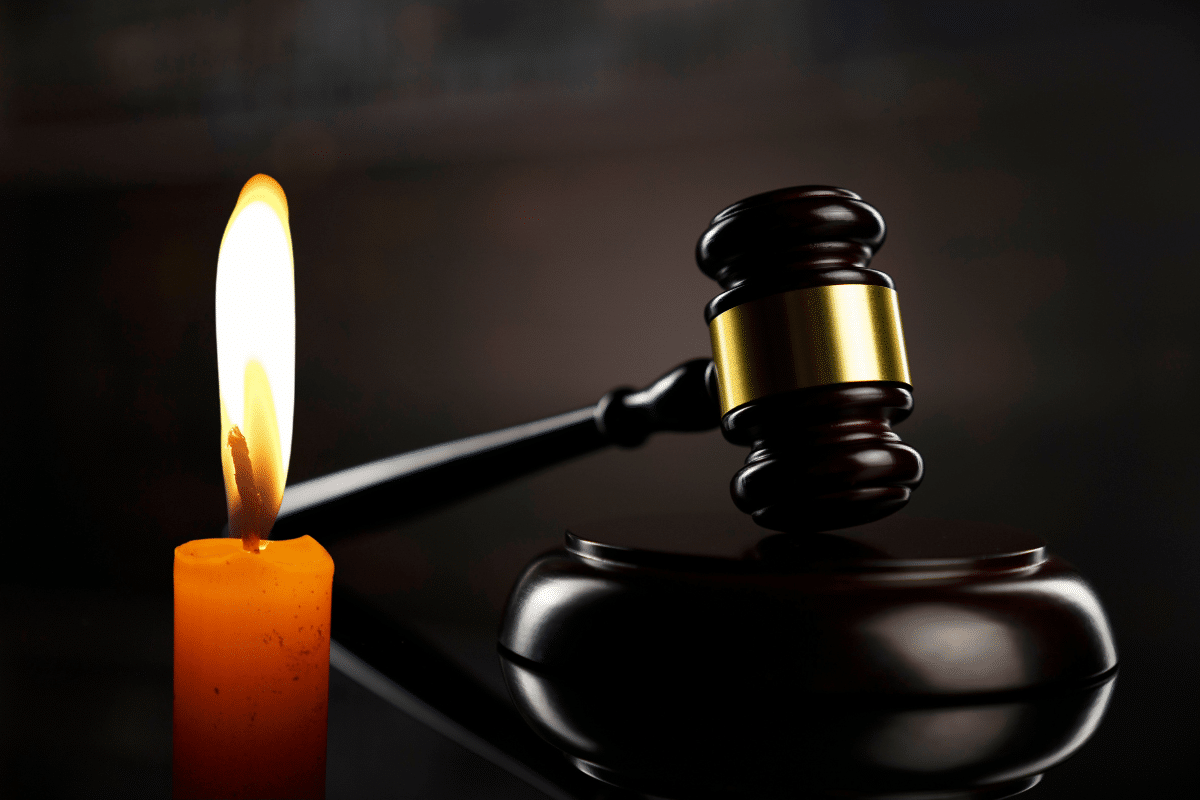 Maillet de juge posé à côté d'une bougie allumée.
