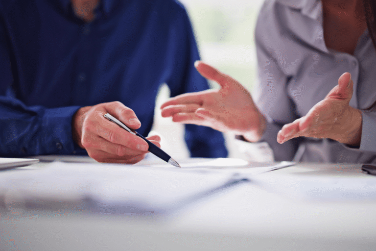 Discussion autour de documents, mains gesticulant.