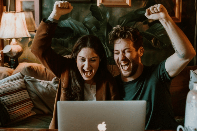 Jeunes adultes célébrant devant un ordinateur portable.