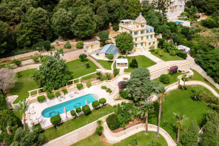 Villa avec piscine entourée de jardins luxuriants.