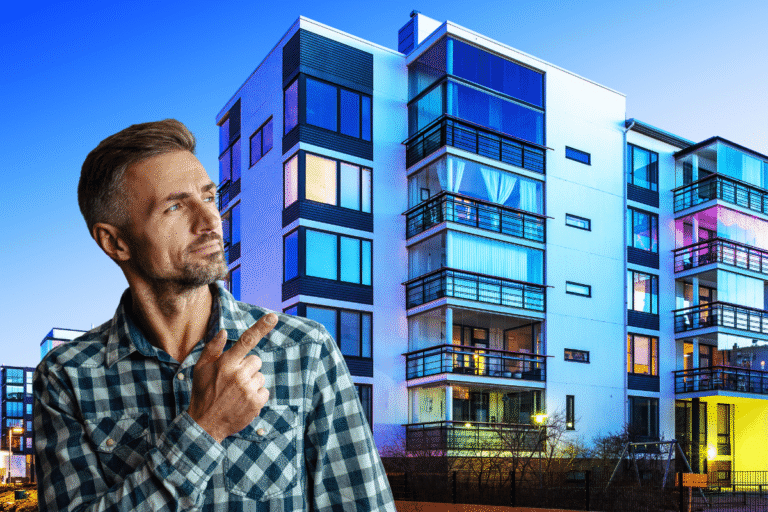 Homme pensif devant un immeuble moderne illuminé.