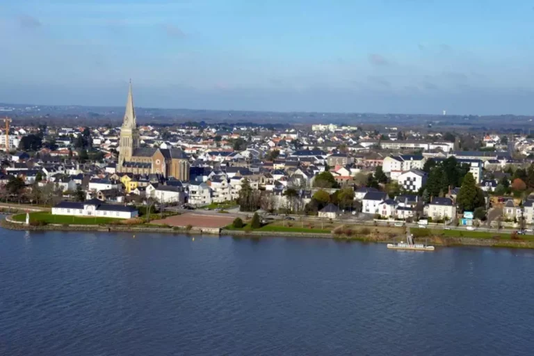 Vue panoramique d'une ville au bord de l'eau avec une église.