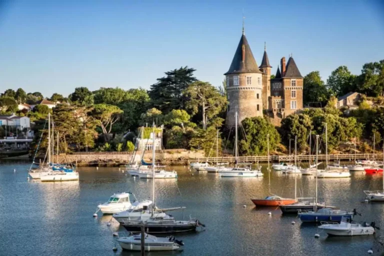 Château au bord de l'eau avec plusieurs bateaux.