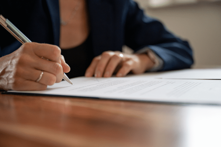 Main tenant un stylo, signant un document.