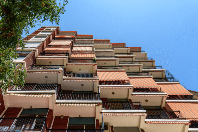 Façade d'immeuble avec balcons et ciel bleu.
