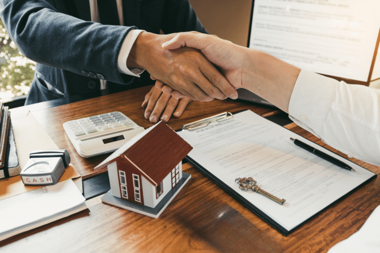 Poignée de main au-dessus d'un contrat immobilier.