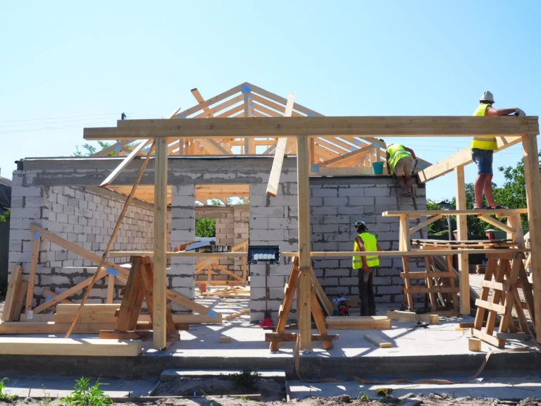 Construction d'une maison avec ouvriers et charpente en bois.
