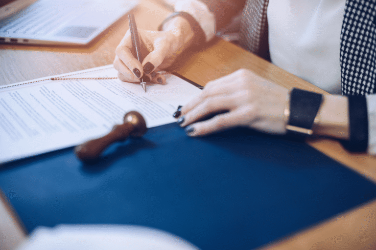 Main écrivant sur un document avec un tampon en bois.