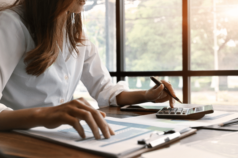 Femme en chemise blanche prenant des notes avec un stylo.