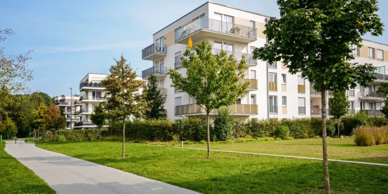 Édifice moderne entouré d'arbre et d'espaces verts.