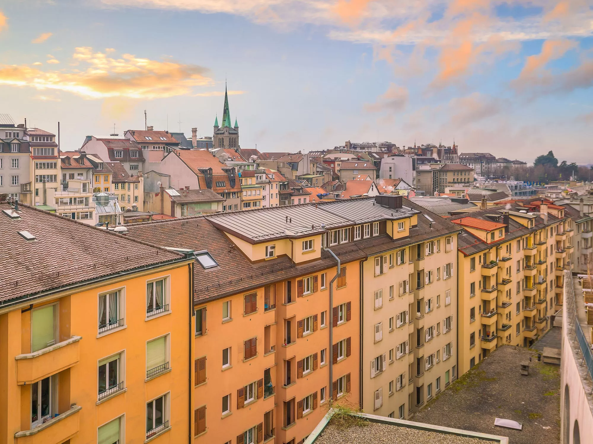 Toits colorés et bâtiments historiques sous un ciel nuageux.