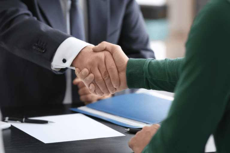 Poignée de main entre deux professionnels en réunion.