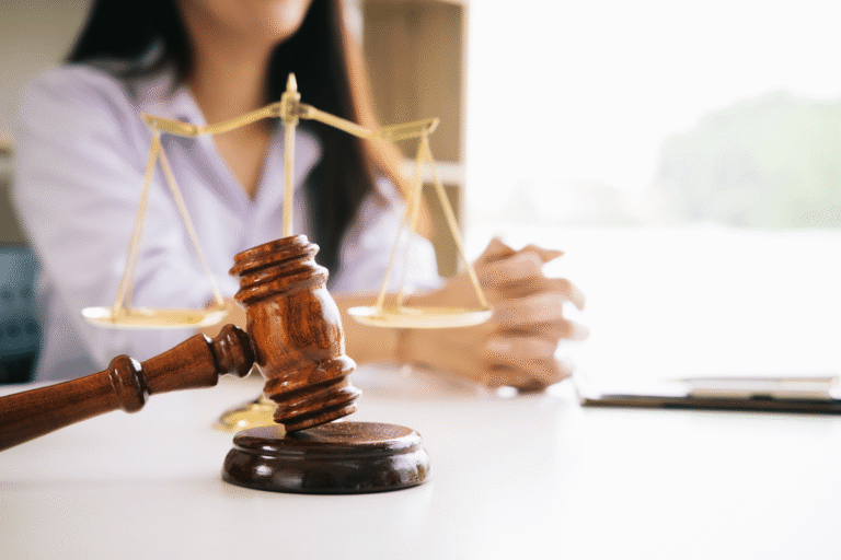 Maillet de juge en bois devant une balance de la justice.