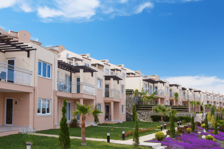 Maisons modernes avec balcons et jardins bien entretenus.