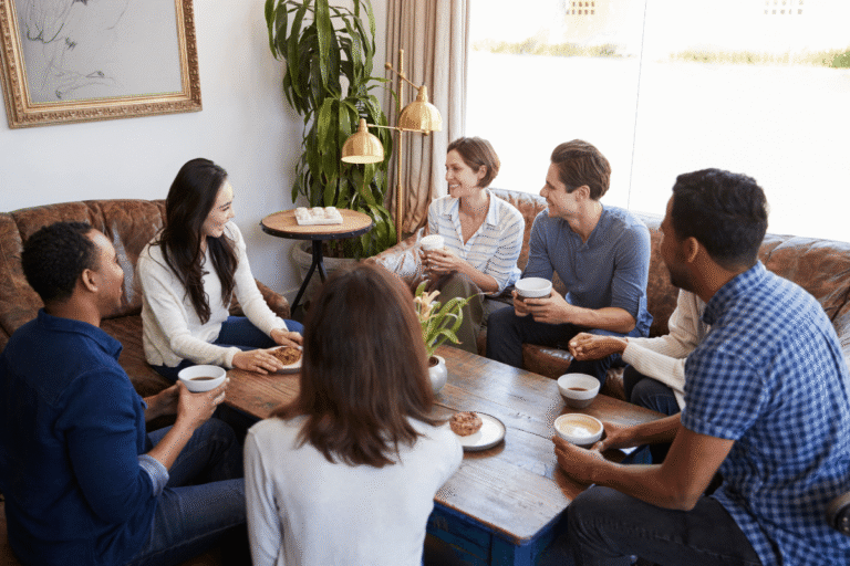 Groupe d'amis discutant autour d'une table en bois.