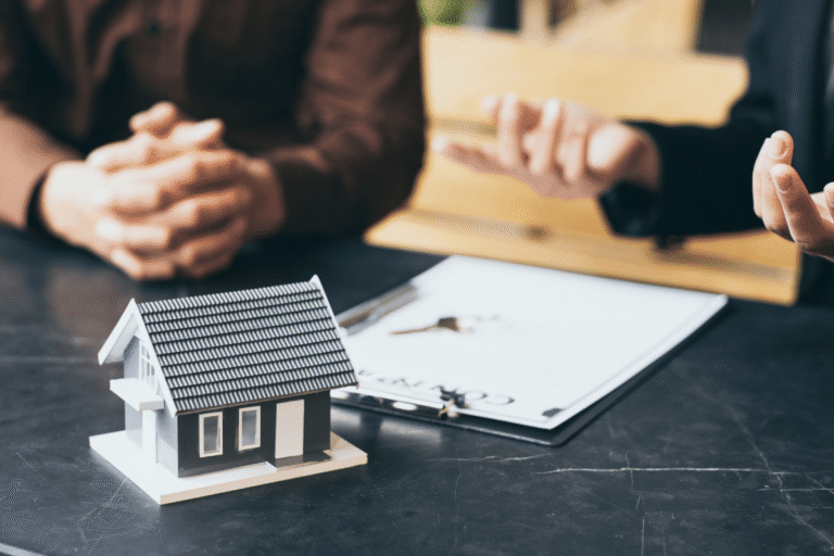 Maquette de maison sur une table avec des documents.